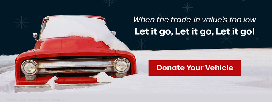 A red old pickup sits covered in snow